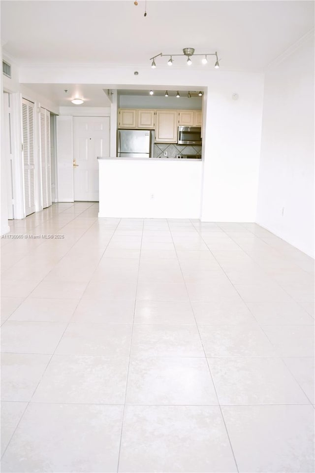 unfurnished living room with light tile patterned floors, crown molding, and visible vents