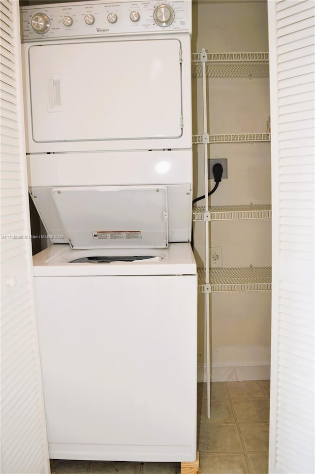 laundry room featuring light tile patterned flooring, stacked washing maching and dryer, and laundry area