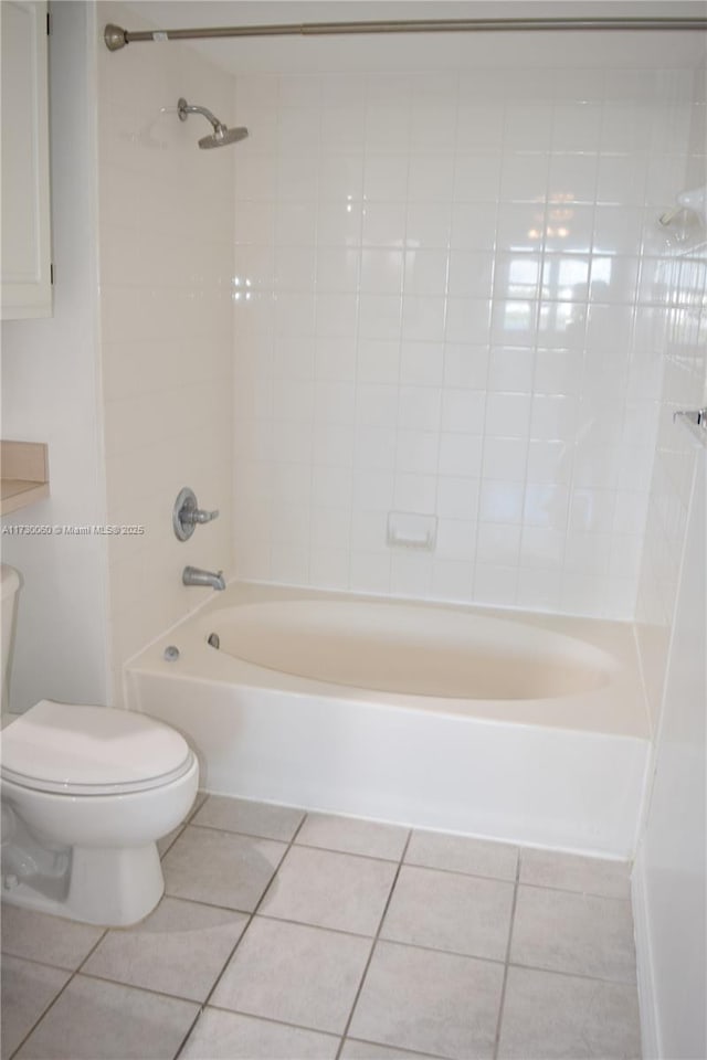 bathroom with bathtub / shower combination, toilet, and tile patterned flooring