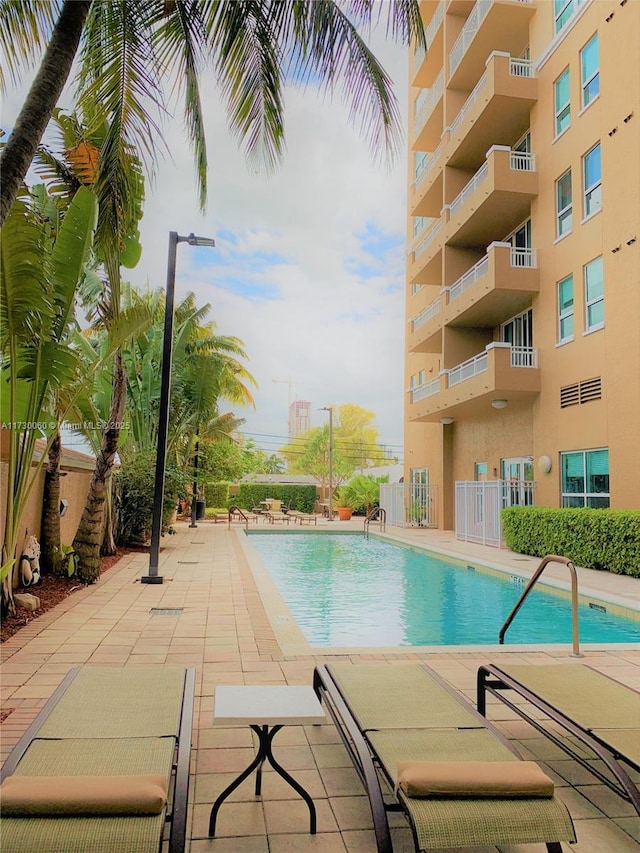 community pool featuring a patio and fence