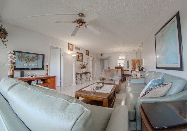 tiled living room with ceiling fan with notable chandelier and a textured ceiling