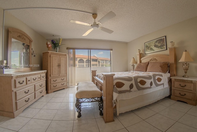 bedroom with ceiling fan, light tile patterned floors, and a textured ceiling