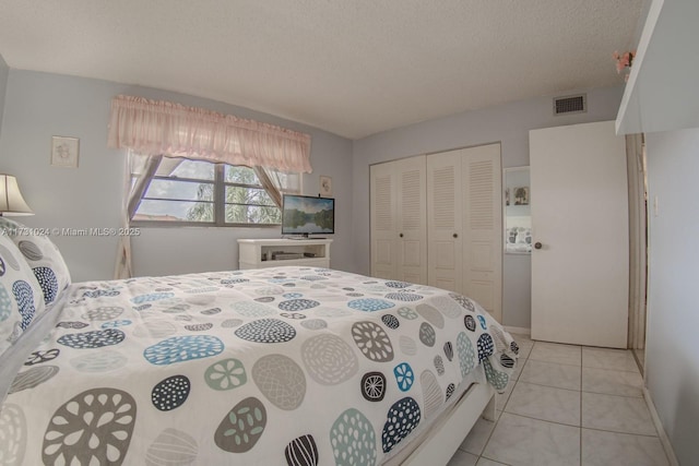 tiled bedroom featuring a textured ceiling and a closet