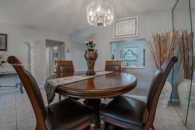 dining area with a textured ceiling and an inviting chandelier