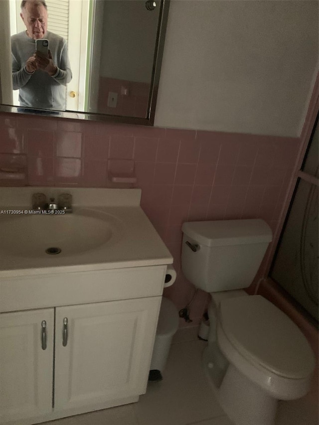 bathroom featuring tile walls, toilet, and vanity