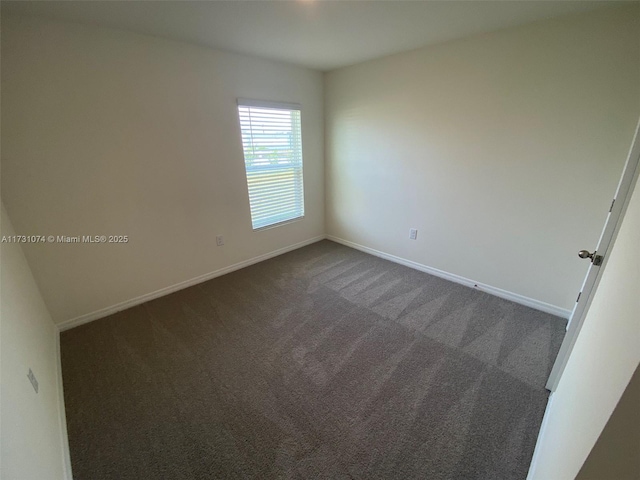 spare room with dark carpet