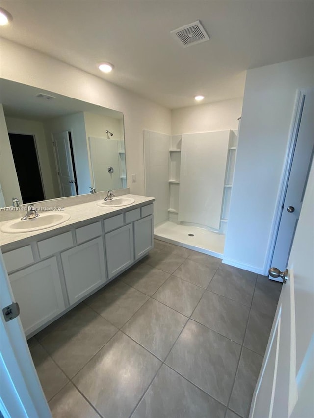 bathroom with vanity, tile patterned flooring, and a shower