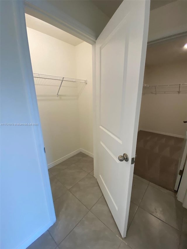 walk in closet with light tile patterned flooring