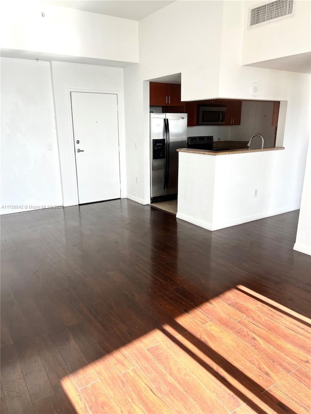 kitchen with dark brown cabinets, dark hardwood / wood-style floors, and stainless steel appliances