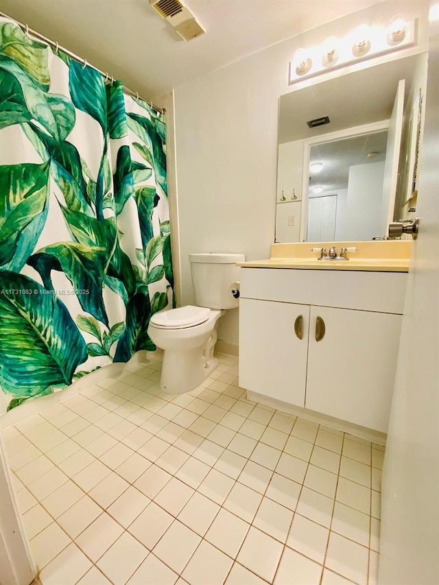 bathroom featuring tile patterned flooring, vanity, and toilet