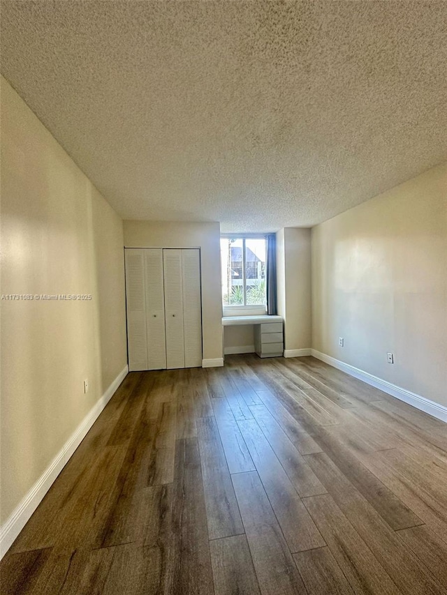 unfurnished bedroom with hardwood / wood-style floors, a textured ceiling, and a closet