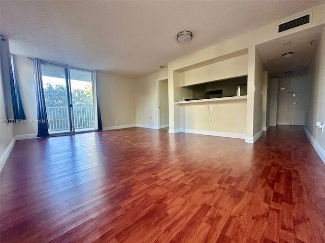 unfurnished living room featuring floor to ceiling windows, hardwood / wood-style floors, and a textured ceiling