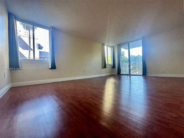 empty room featuring dark wood-type flooring and a textured ceiling