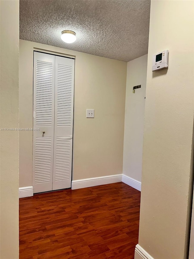 corridor featuring hardwood / wood-style flooring and a textured ceiling