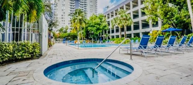 view of pool featuring a hot tub and a patio