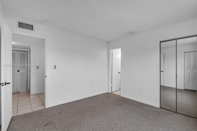 unfurnished bedroom featuring light carpet and a textured ceiling