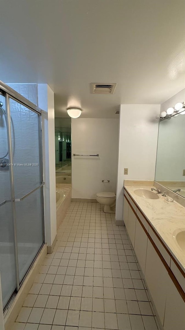 full bathroom featuring independent shower and bath, vanity, tile patterned floors, and toilet