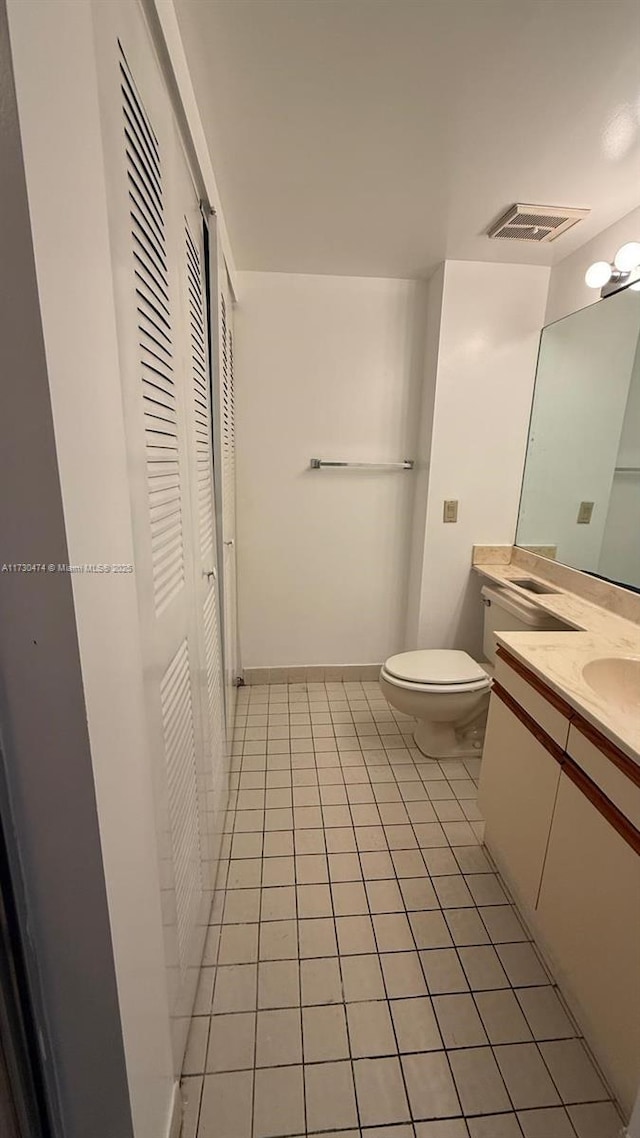 bathroom with tile patterned flooring, vanity, and toilet