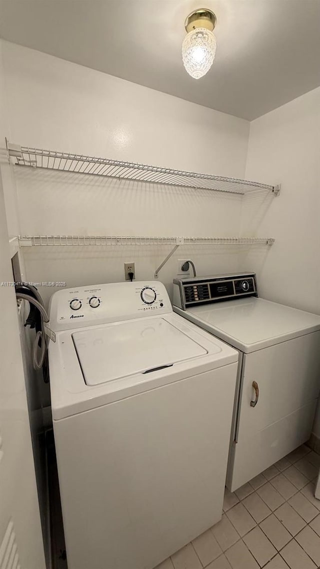 washroom with light tile patterned floors and washer and clothes dryer