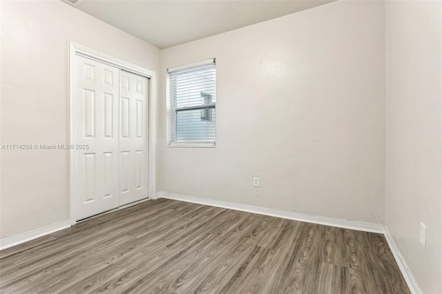 unfurnished bedroom featuring a closet and wood-type flooring