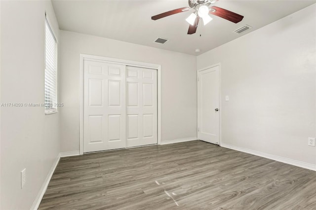 unfurnished bedroom with a closet, ceiling fan, and wood-type flooring