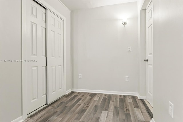 unfurnished bedroom with a closet and dark hardwood / wood-style flooring