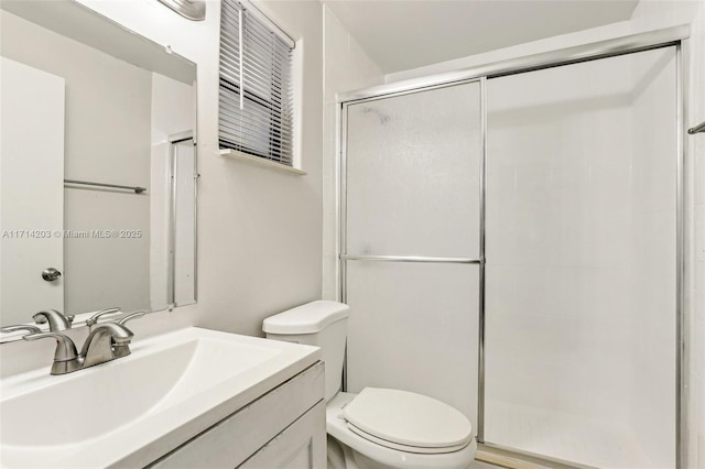 bathroom with toilet, a shower with door, and vanity