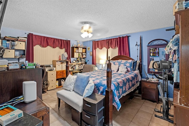 tiled bedroom with ceiling fan and a textured ceiling