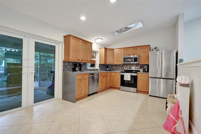 kitchen featuring french doors, light tile patterned flooring, vaulted ceiling, stainless steel appliances, and backsplash