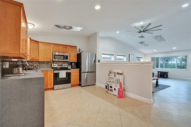 kitchen featuring tasteful backsplash, vaulted ceiling, light tile patterned floors, appliances with stainless steel finishes, and ceiling fan