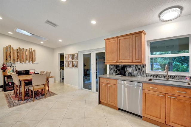 kitchen featuring sink, light tile patterned floors, stainless steel dishwasher, and backsplash