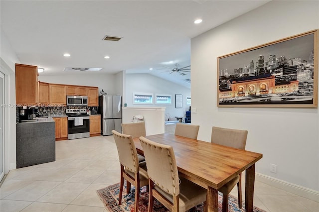 dining space with vaulted ceiling, light tile patterned floors, and ceiling fan