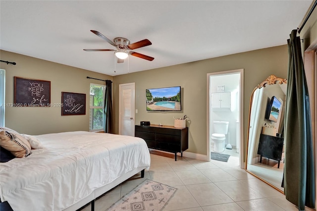 bedroom with light tile patterned flooring, a closet, ceiling fan, and ensuite bath