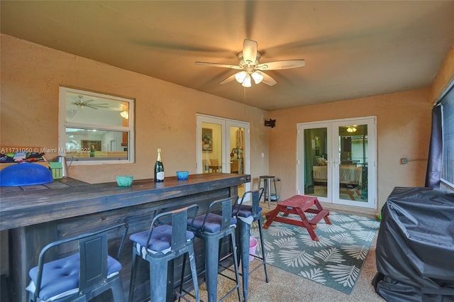 view of patio with french doors, ceiling fan, an outdoor bar, and area for grilling