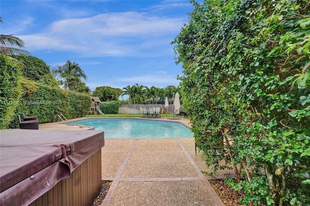 view of swimming pool with a hot tub and a patio