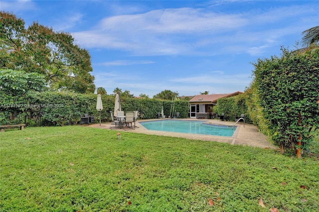 view of pool featuring a yard and a patio