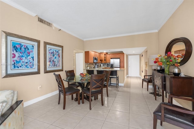 dining room featuring crown molding and light tile patterned floors