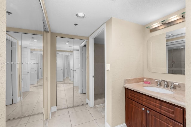 bathroom featuring vanity, tile patterned floors, and a textured ceiling