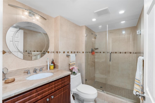 bathroom with toilet, tile walls, an enclosed shower, and vanity