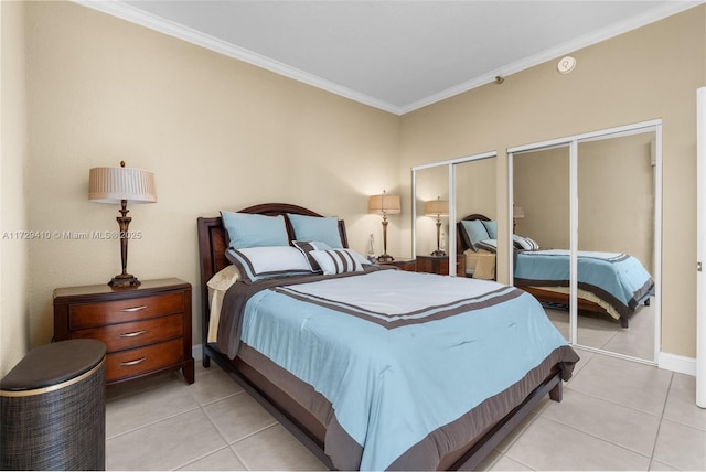 bedroom with crown molding, light tile patterned floors, and two closets