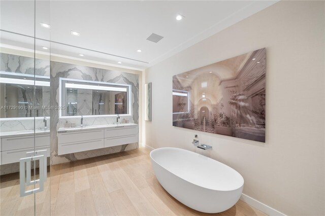 bathroom featuring vanity, hardwood / wood-style floors, and a tub