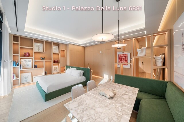 bedroom featuring a tray ceiling and light wood-type flooring