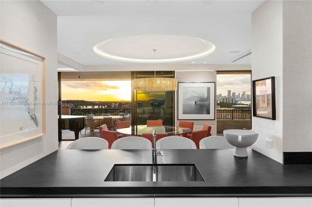 kitchen with black electric cooktop, sink, light hardwood / wood-style floors, and white cabinets