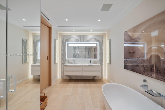 bathroom featuring vanity, hardwood / wood-style floors, and a bathing tub