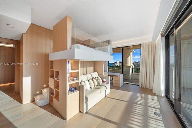 bedroom with light wood-type flooring and wood walls