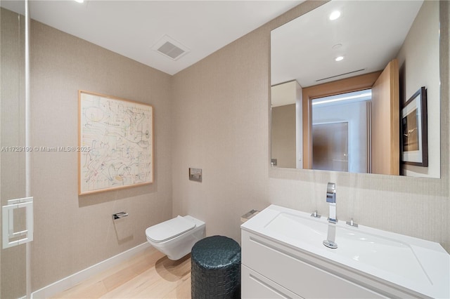 bathroom featuring vanity, wood-type flooring, and toilet