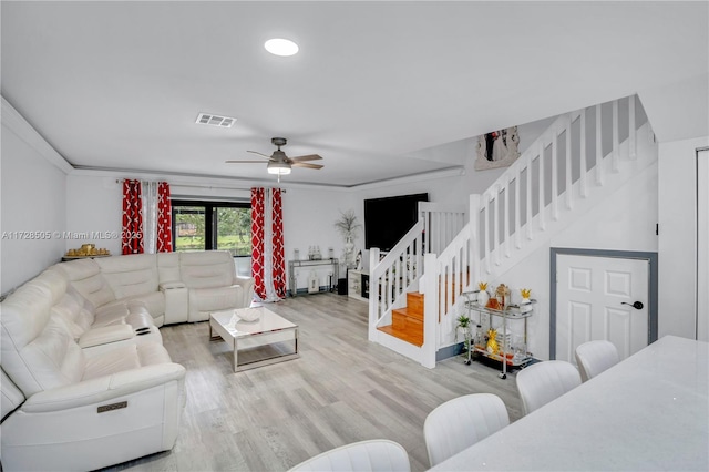 living room with visible vents, ceiling fan, stairway, and wood finished floors