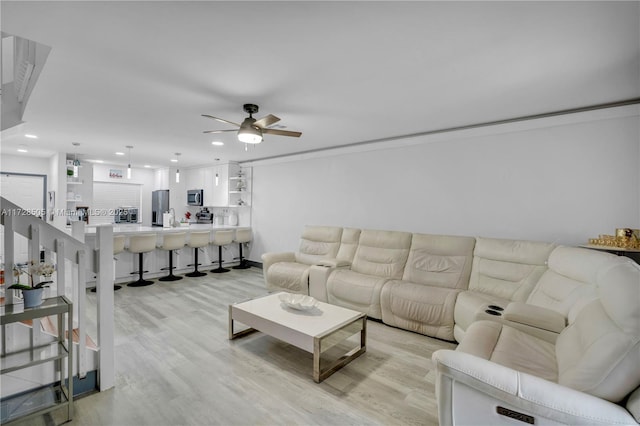 living room featuring light wood-type flooring, ceiling fan, and recessed lighting