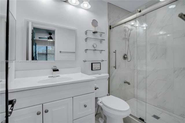 full bathroom featuring toilet, a marble finish shower, a ceiling fan, and vanity