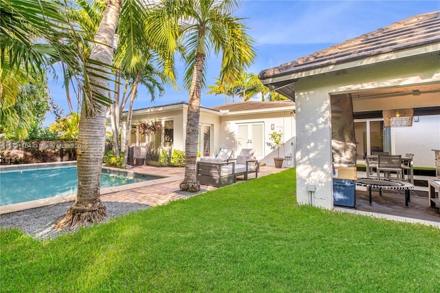 back of house with a yard, an outdoor pool, a patio, and stucco siding